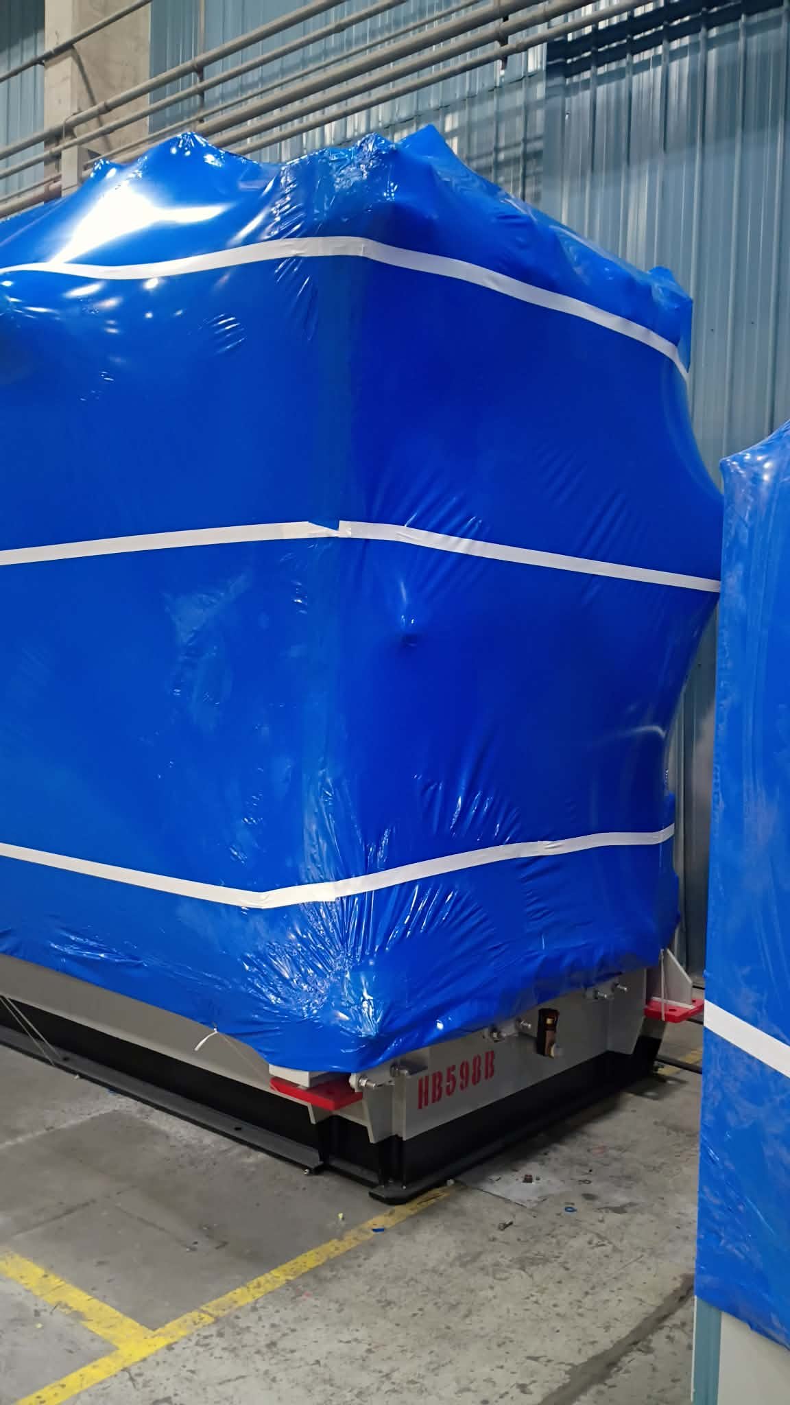 Shrink-wrapped heavy electrical equipment with crane overhead